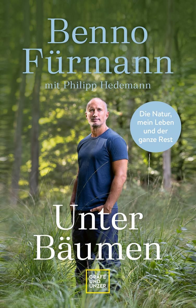 Buchcover: "Unter Bäumen" von Benno Fürmann. Der Autor steht im Wald. Titel und Autorennamen sind deutlich sichtbar.