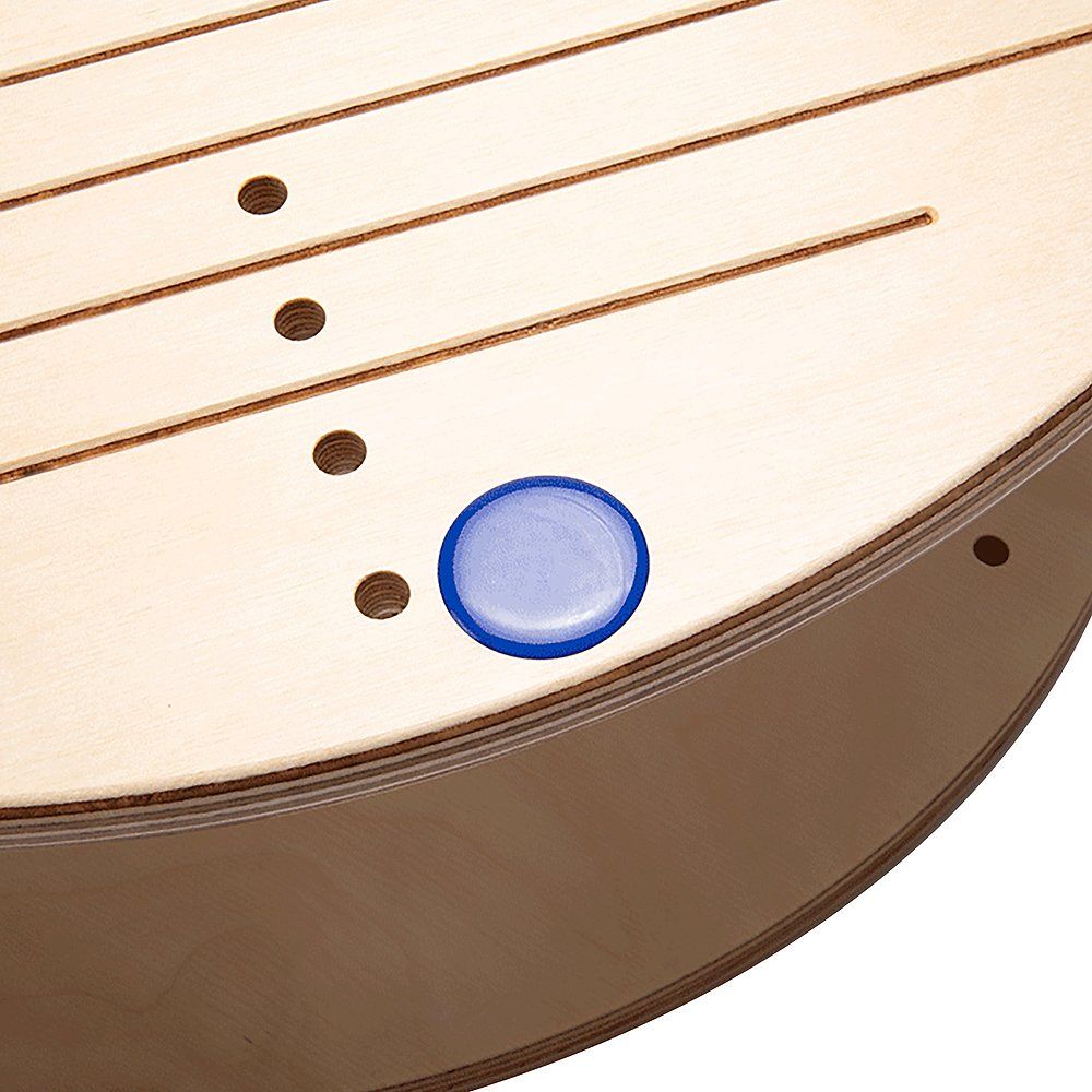 Nahaufnahme eines Pedalo Gleichgewichtstrainers. Holzoberfläche mit Bohrungen und einem blauen Kunststoffelement.