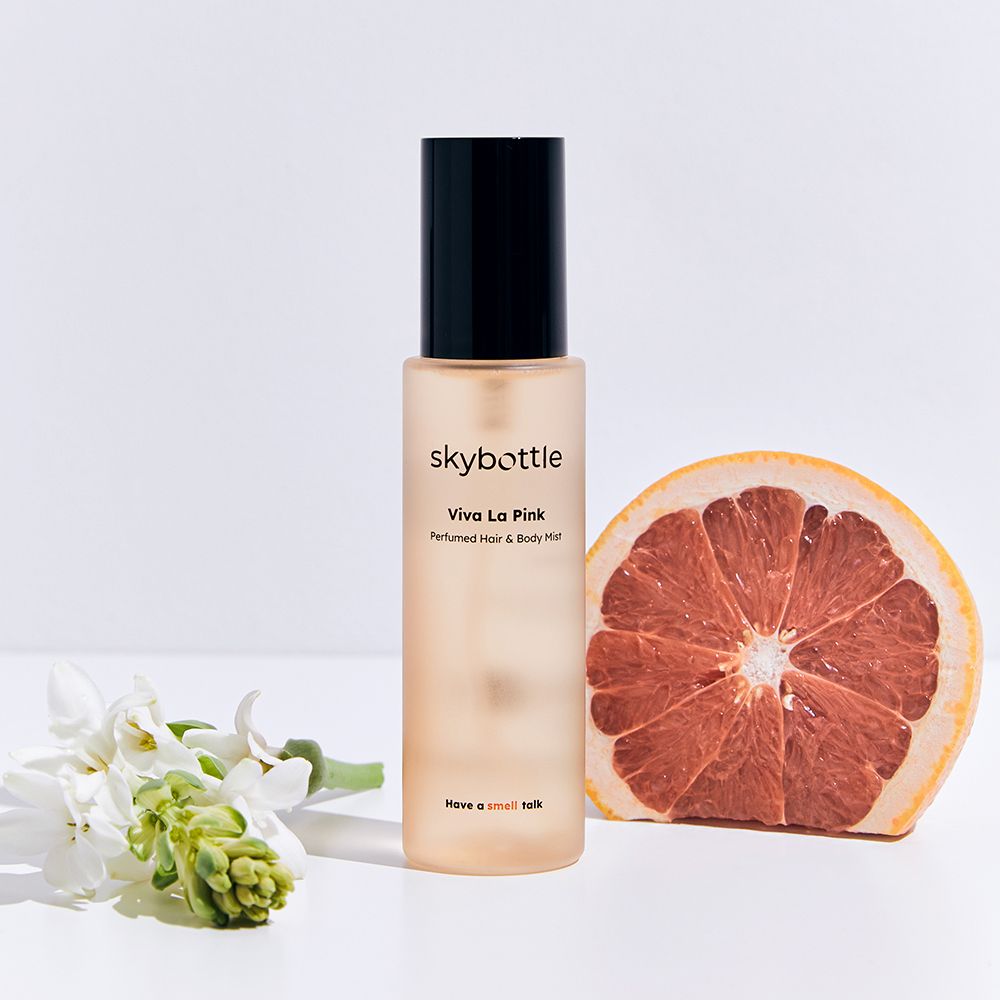 SKYBOTTLE Viva La Pink Hair & Body Mist, Grapefruit-Hälfte und Blumen. Text.