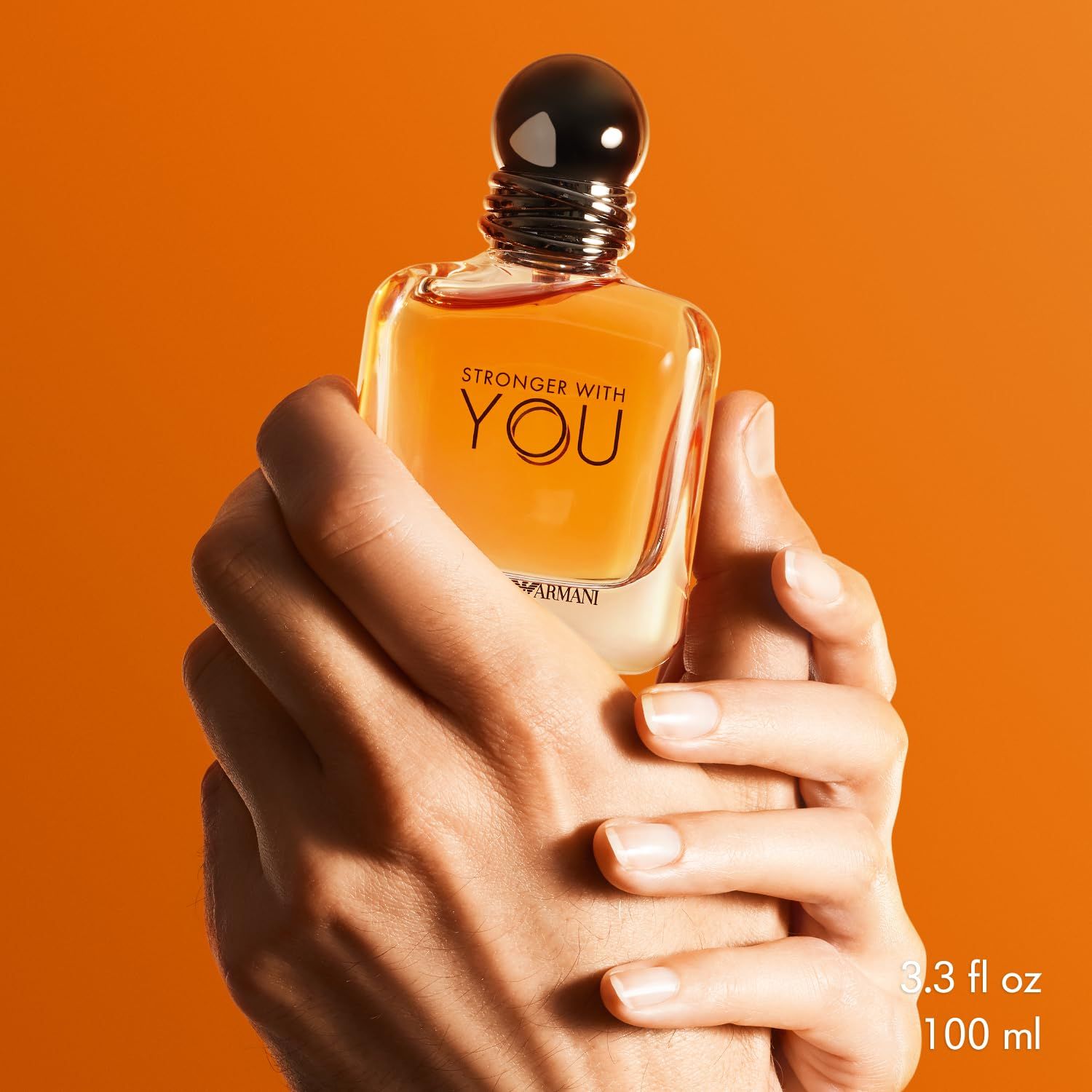 Parfümflakon in Händen gehalten. Aufschrift: STRONGER WITH YOU und EMPORIO ARMANI. Volumen: 3.3 fl oz / 100 ml.