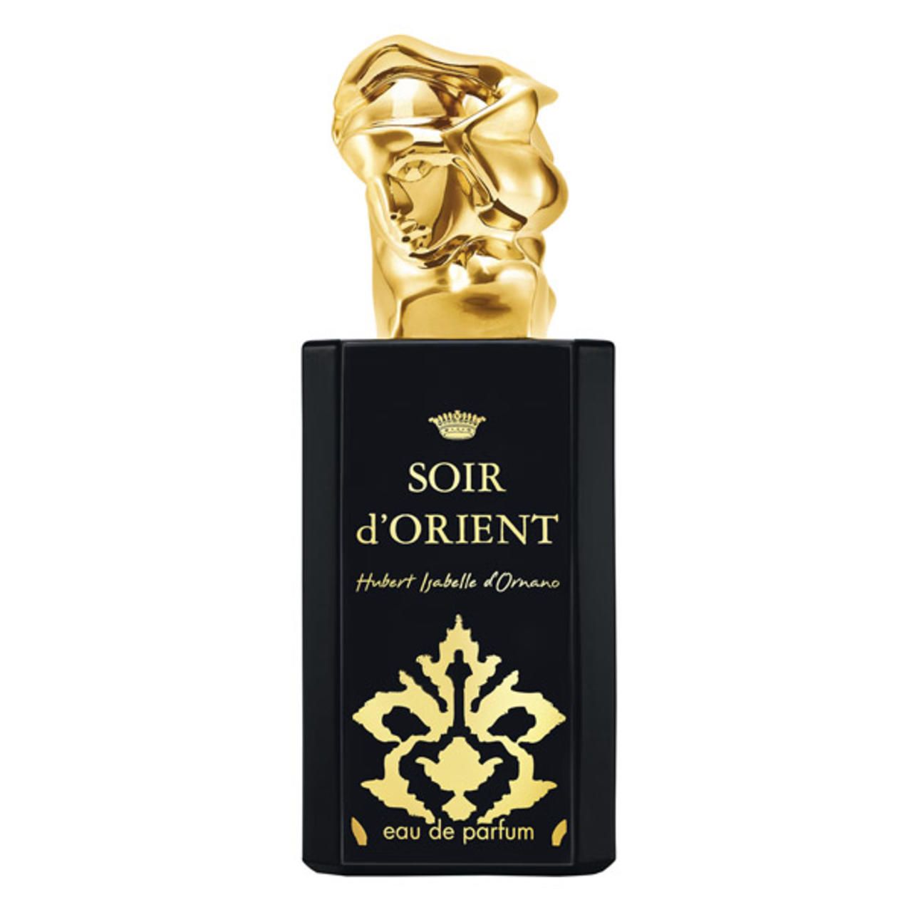 Schwarzer Flakon mit goldener Kappe. Aufschrift: Soir d'Orient, Eau de Parfum. Goldene Verzierungen.