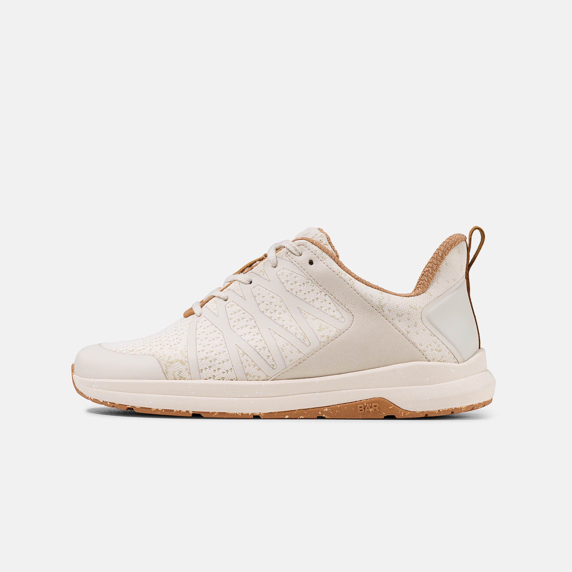 Cremefarbener Unisex-Sneaker mit Schnürsenkeln. Braune Akzente an Zunge, Ferse und Sohle. Mesh-Obermaterial.