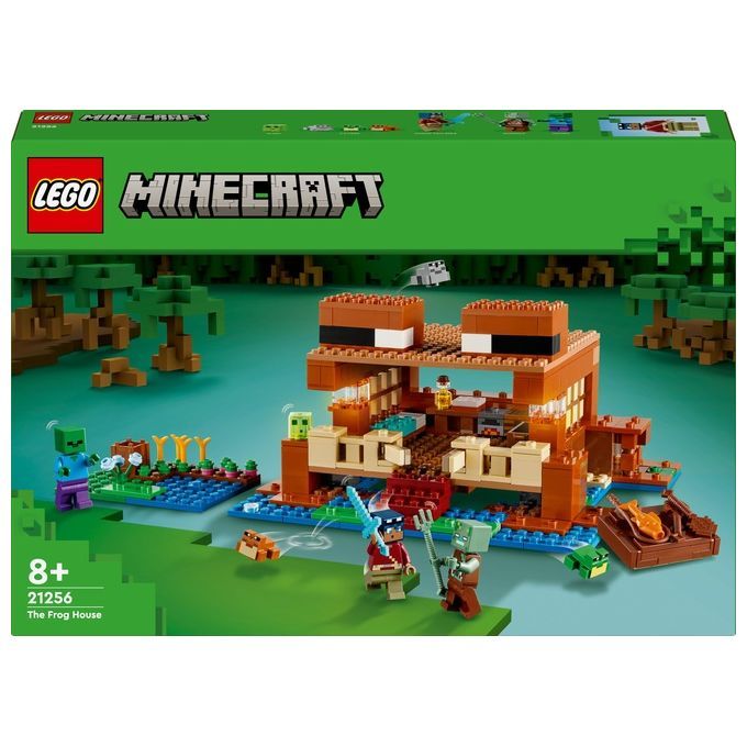 LEGO Minecraft 21256 La Casa-Rana. La confezione mostra il modello assemblato: una casa marrone a forma di rana, circondata da personaggi ed elementi di Minecraft. Adatto a bambini dagli 8 anni in su. Include personaggi e accessori.
