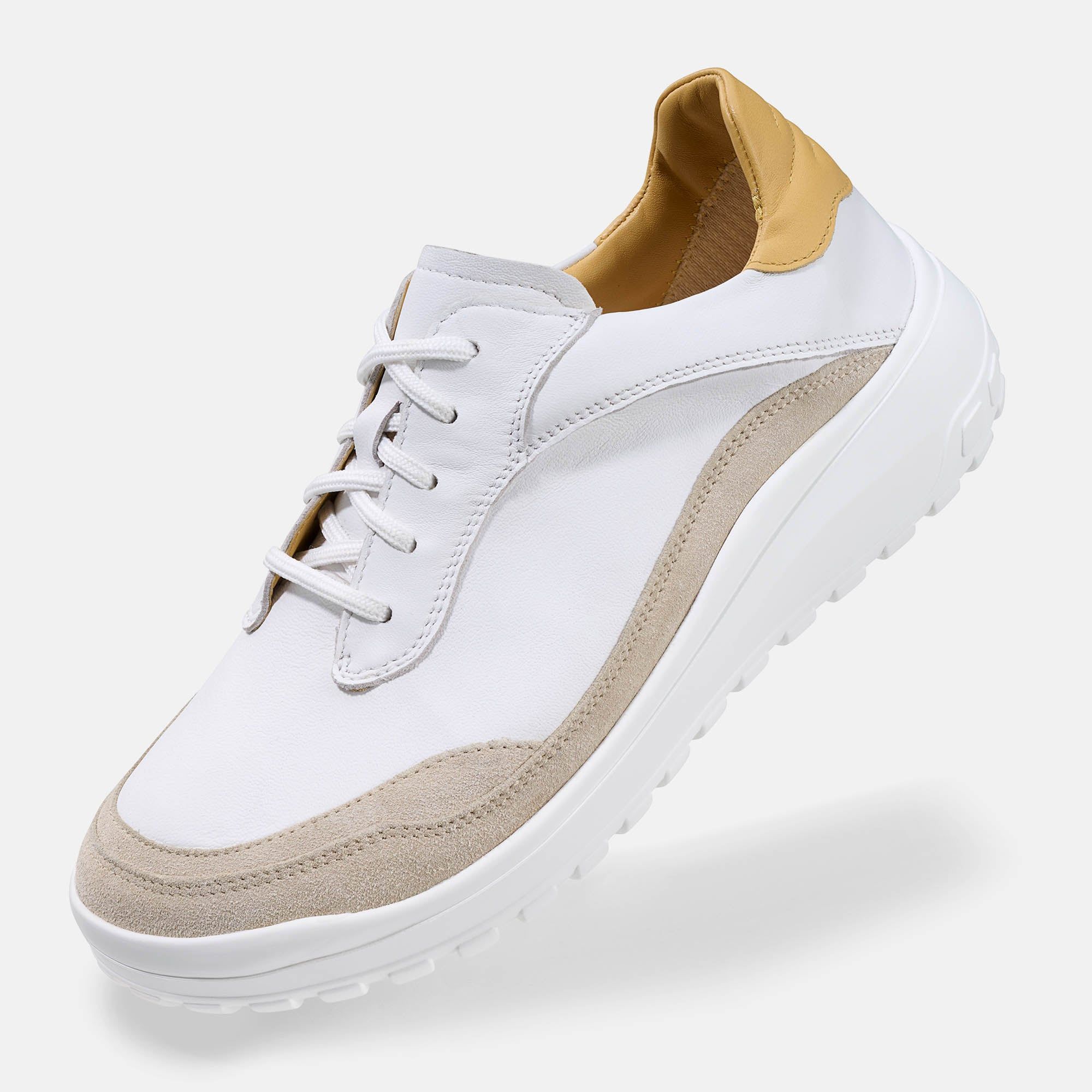 Weißer Schnürschuh mit beigen Akzenten und gelben Details. Breite Form, helles Design.