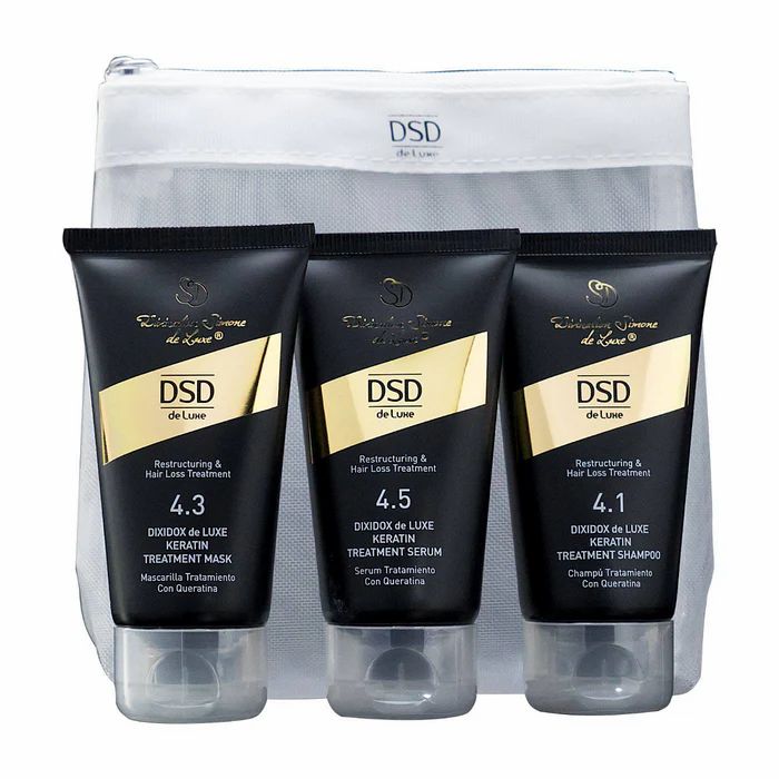 Set mit drei Haarpflegeprodukten in schwarzen Tuben mit goldfarbenen Akzenten. Aufschrift: DSD de Luxe. Enthalten sind Maske, Serum und Shampoo.