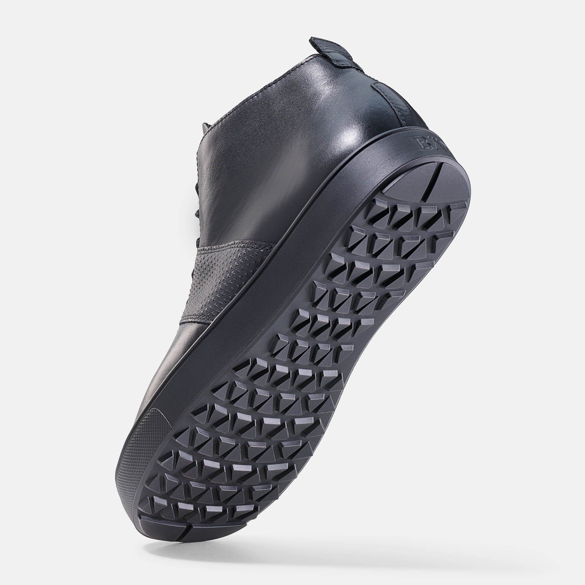 Schwarze Stiefelette, Unterseite mit geometrischem Muster. BÄR-Logo auf der Zunge. Hellgrauer Hintergrund.