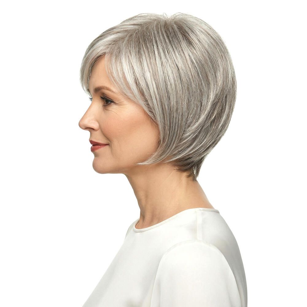 Kurzhaarperücke in Grau mit Seitenscheitel. Die Frau trägt ein weißes Oberteil. Profilansicht.