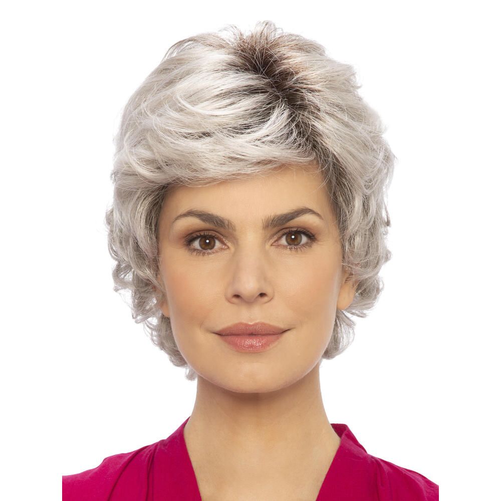 Perücke mit grauen, gewellten Haaren. Frontale Ansicht einer Frau mit der Perücke. Der Ansatz ist dunkelbraun.
