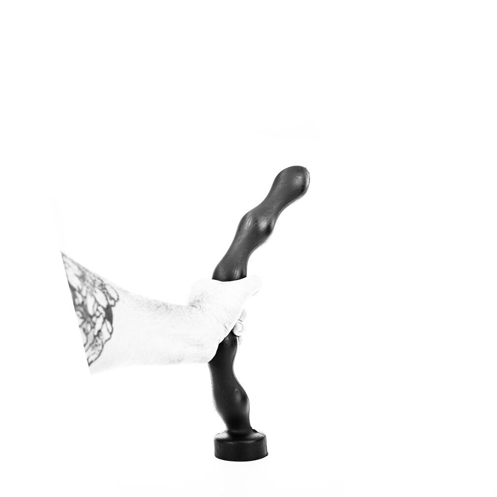 Schwarzer Analplug, gehalten von einer Hand mit Tätowierung. Kugelförmiger Kopf, geriffelte Oberfläche, runde Basis.