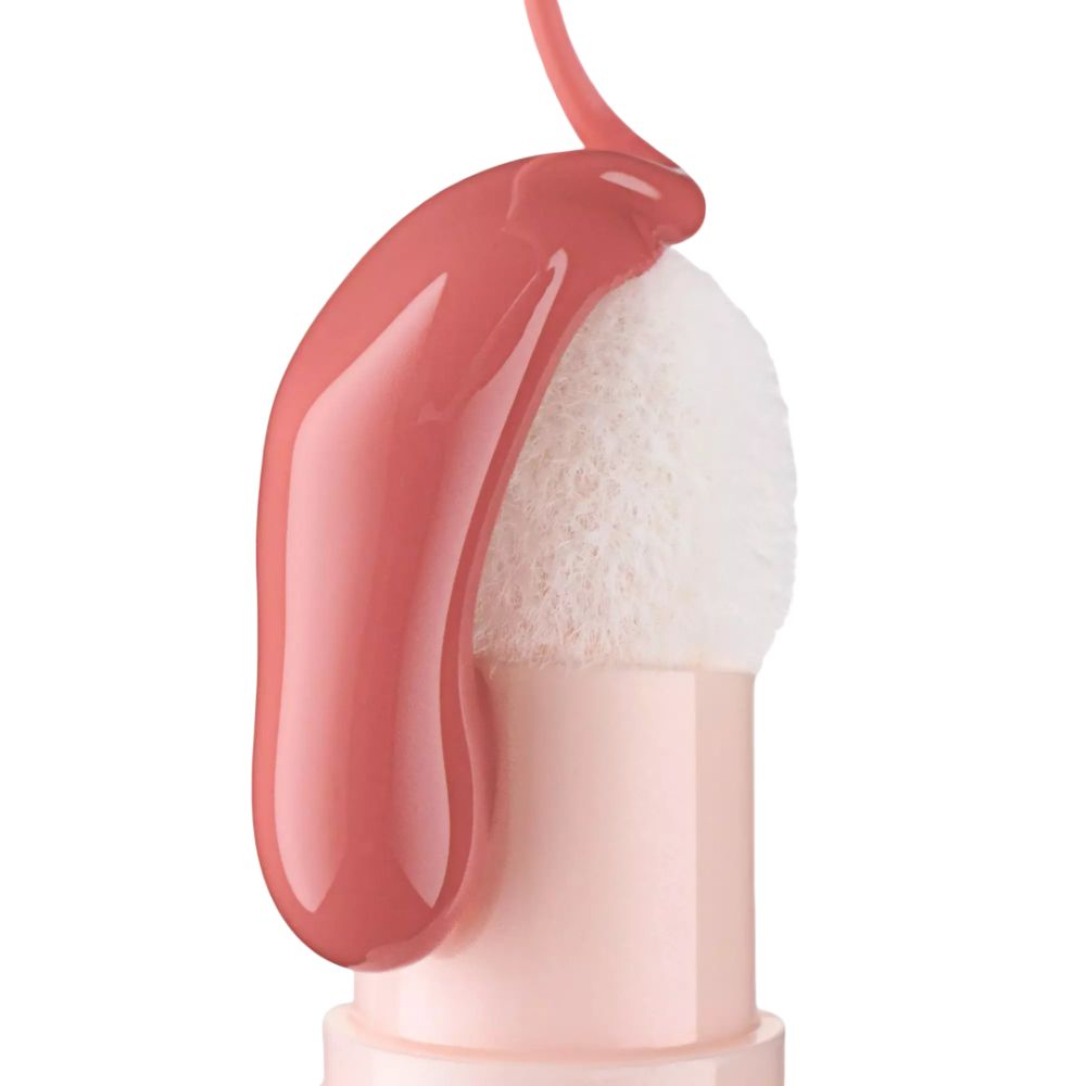 Rosa flüssiges Produkt tropft auf einen weißen Applikator.