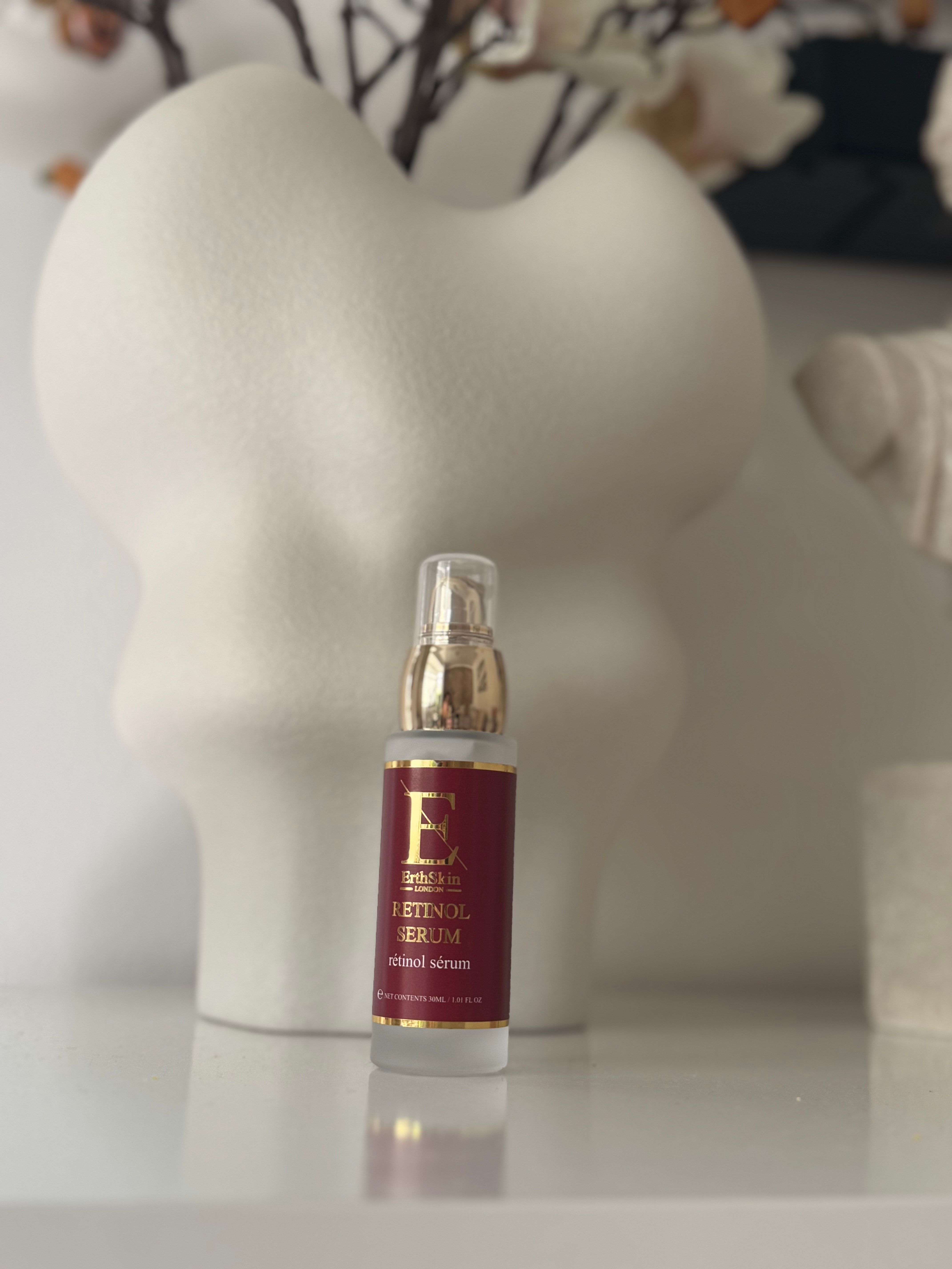 Retinol Serum in einer Glasflasche mit goldenem Deckel. Rote Etikett mit Logo. ErthSkin London.