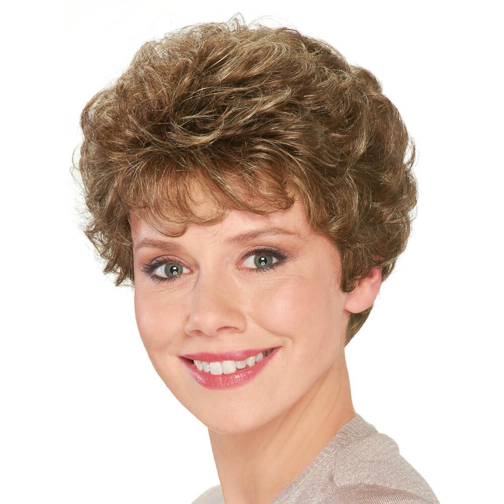 Perücke mit lockigem Haar, hellbraun meliert. Frau mit Lächeln, Blickrichtung nach vorn.