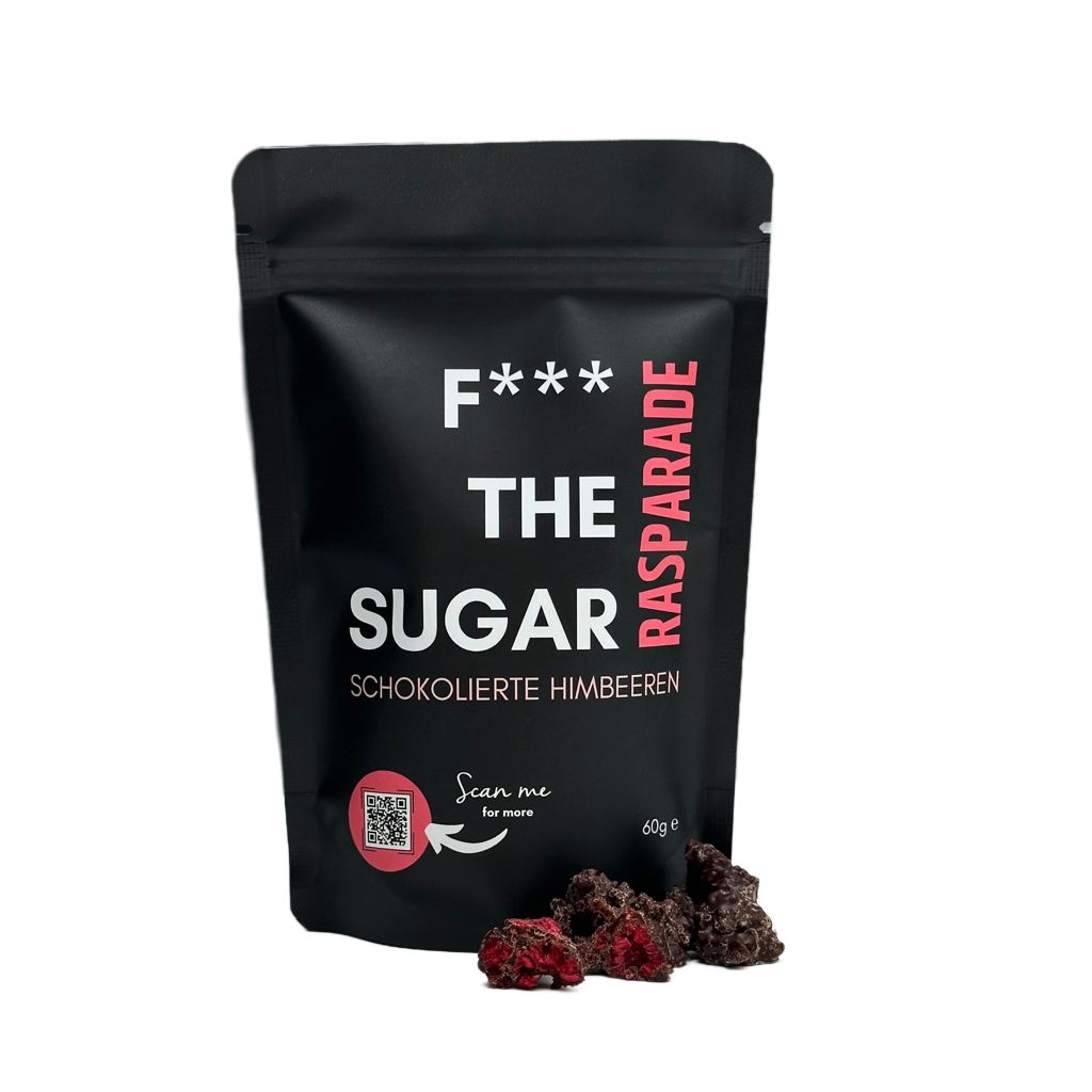 Schwarzer Beutel "F*** THE SUGAR" mit Schoko-Himbeeren. Aufschrift: Raspaprade. QR-Code. Einige Schoko-Himbeeren daneben.