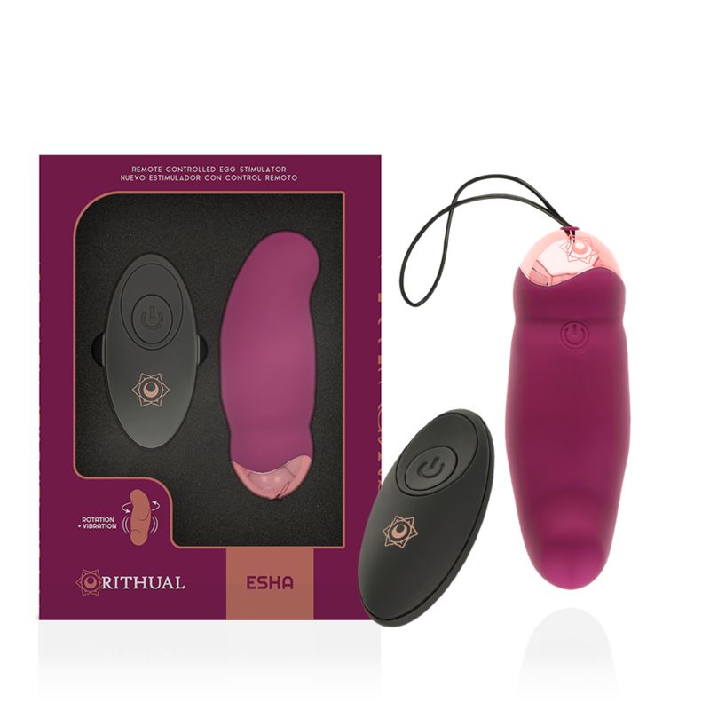 Lila Vibrator und Fernbedienung in Verpackung. Aufschrift: Rithual, Esha. Fernbedienung mit Symbol.