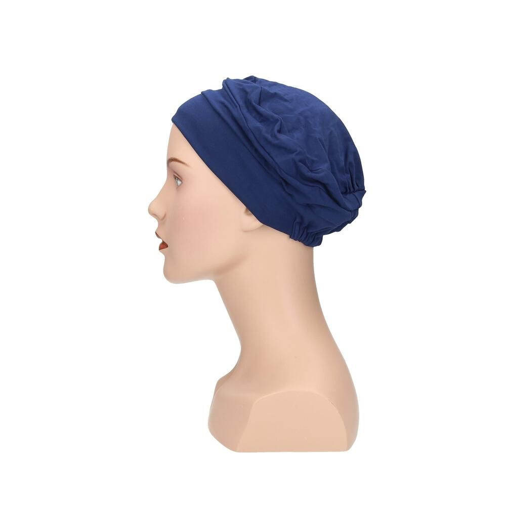 Blauer Turban auf einer Büste. Seitenansicht. Stoffhaube mit gerafftem Design.