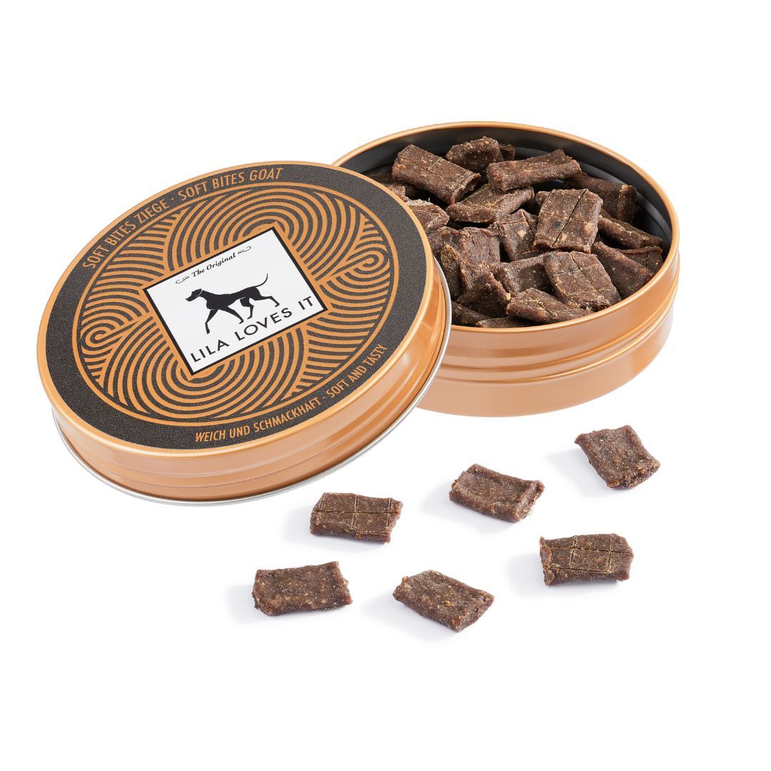 Geöffnete Dose mit rechteckigen, braunen Snacks. Einige Snacks liegen daneben. Aufschrift "LILA LOVES IT".
