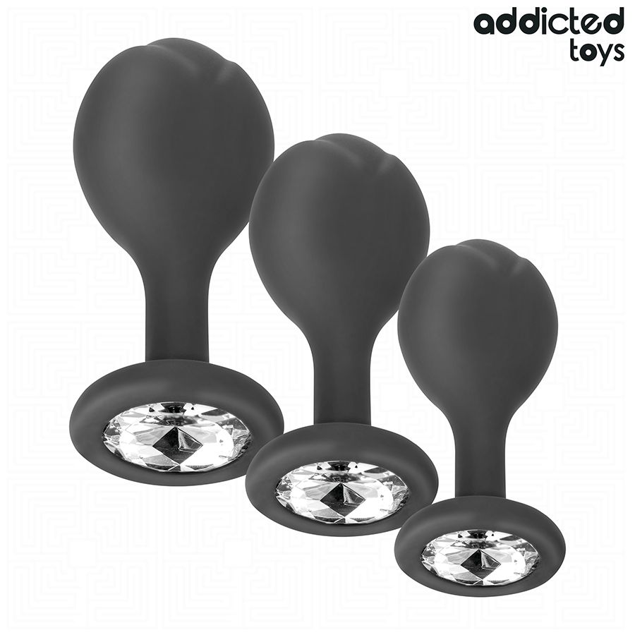Drei graue Analplugs mit Juwel-Set. Jedes hat eine ovale Basis mit einem Kristall. Marke: Addicted Toys.