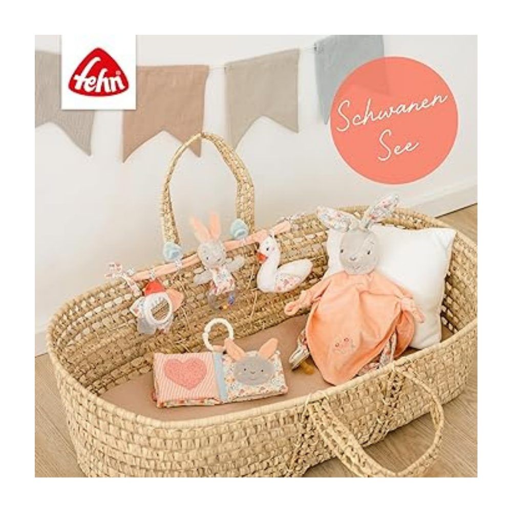 Spielzeugkette in Babybett. Hase, Ente, Blume, Buch und Kuscheltuch. Marke Fehn. Text: Schwanensee.