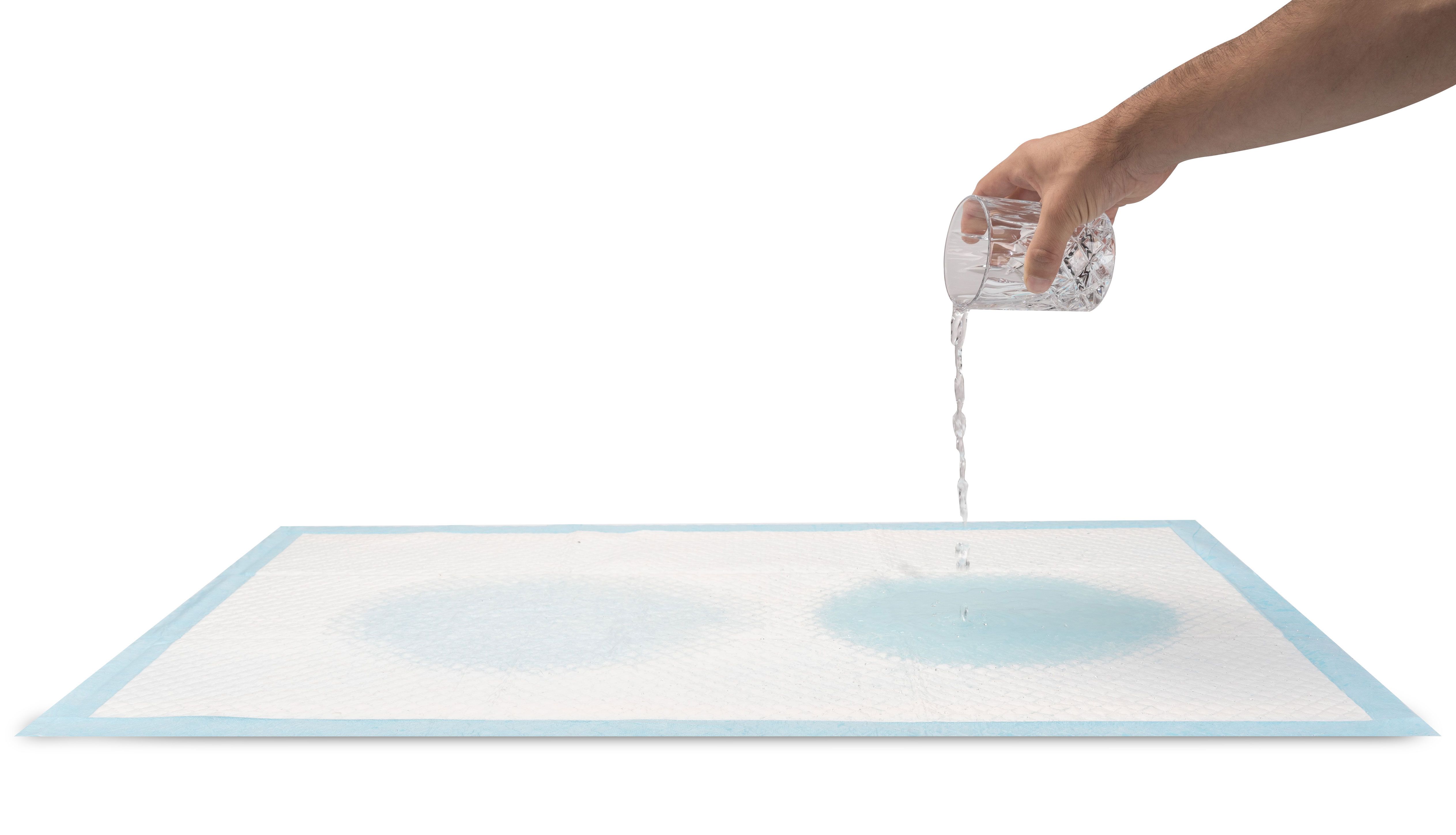 Inkontinenz Unterlage, rechteckig, blau umrandet. Wasser wird auf die Oberfläche gegossen, zeigt Absorption.