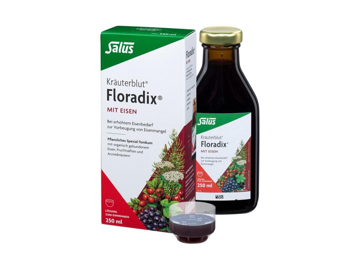 Kräuterblut Floradix mit Eisen. Flasche und Verpackung. Braune Flüssigkeit, Glasflasche mit goldenem Deckel. Becher.