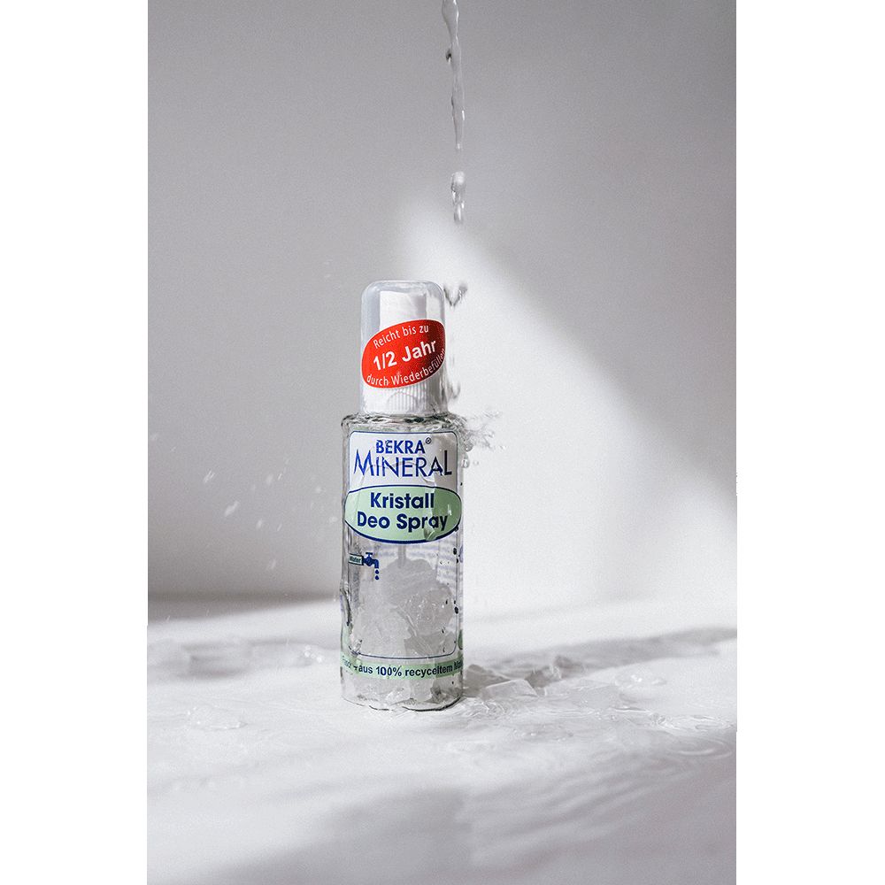 Deospray-Flasche mit Wasserstrahl. Aufschrift: Bekra Mineral Kristall Deo Spray. Roter Aufkleber: 1/2 Jahr.
