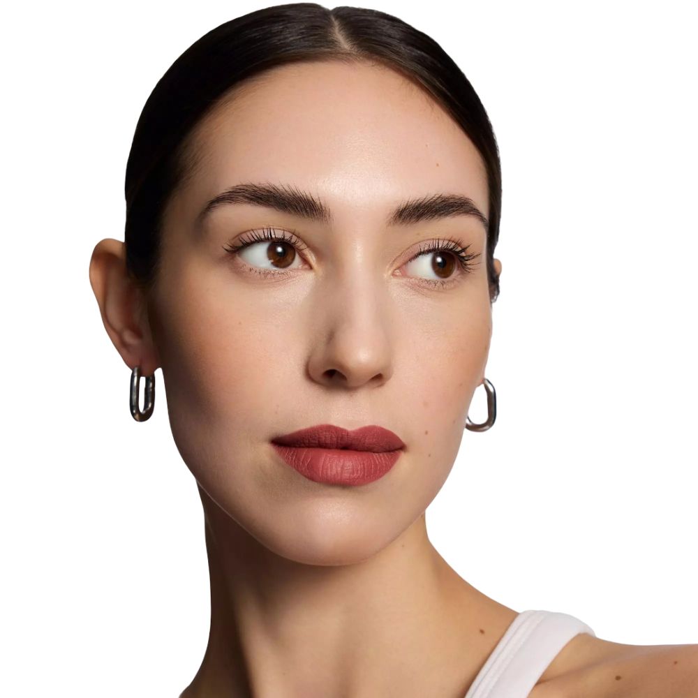 Porträt einer Frau mit Lippenstift. Hellere Haut, glattes Haar, silberne Ohrringe. Lippenstift in Nude-Ton.