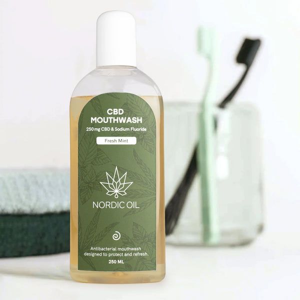 Flasche mit grünem Etikett, neben Zahnbürsten und Handtuch. Etikett mit Text: CBD Mouthwash, Nordic Oil, 250mg CBD & Sodium Fluoride.