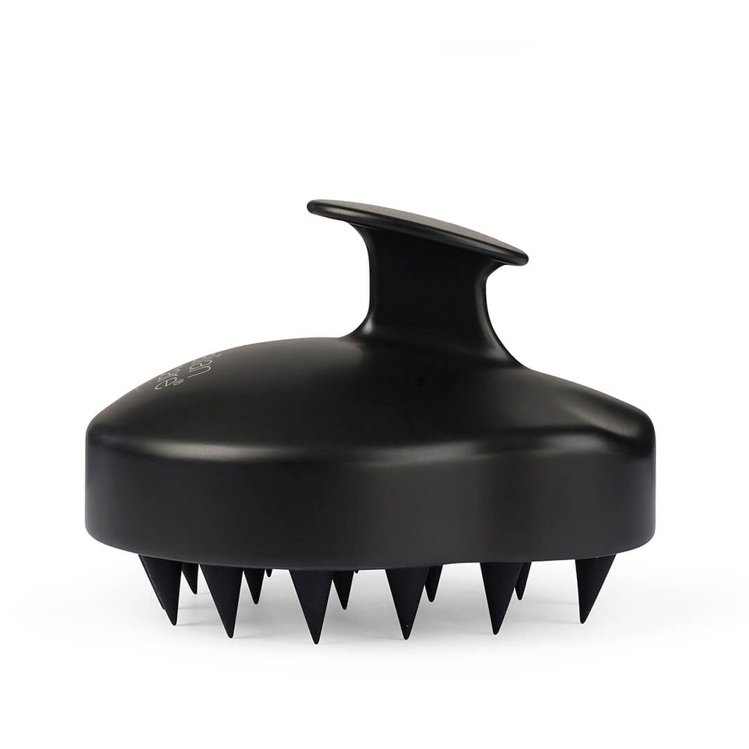 Schwarze Kopfmassagebürste mit Griff und Noppen. Unterseite mit vielen kleinen, spitzen Zähnen.
