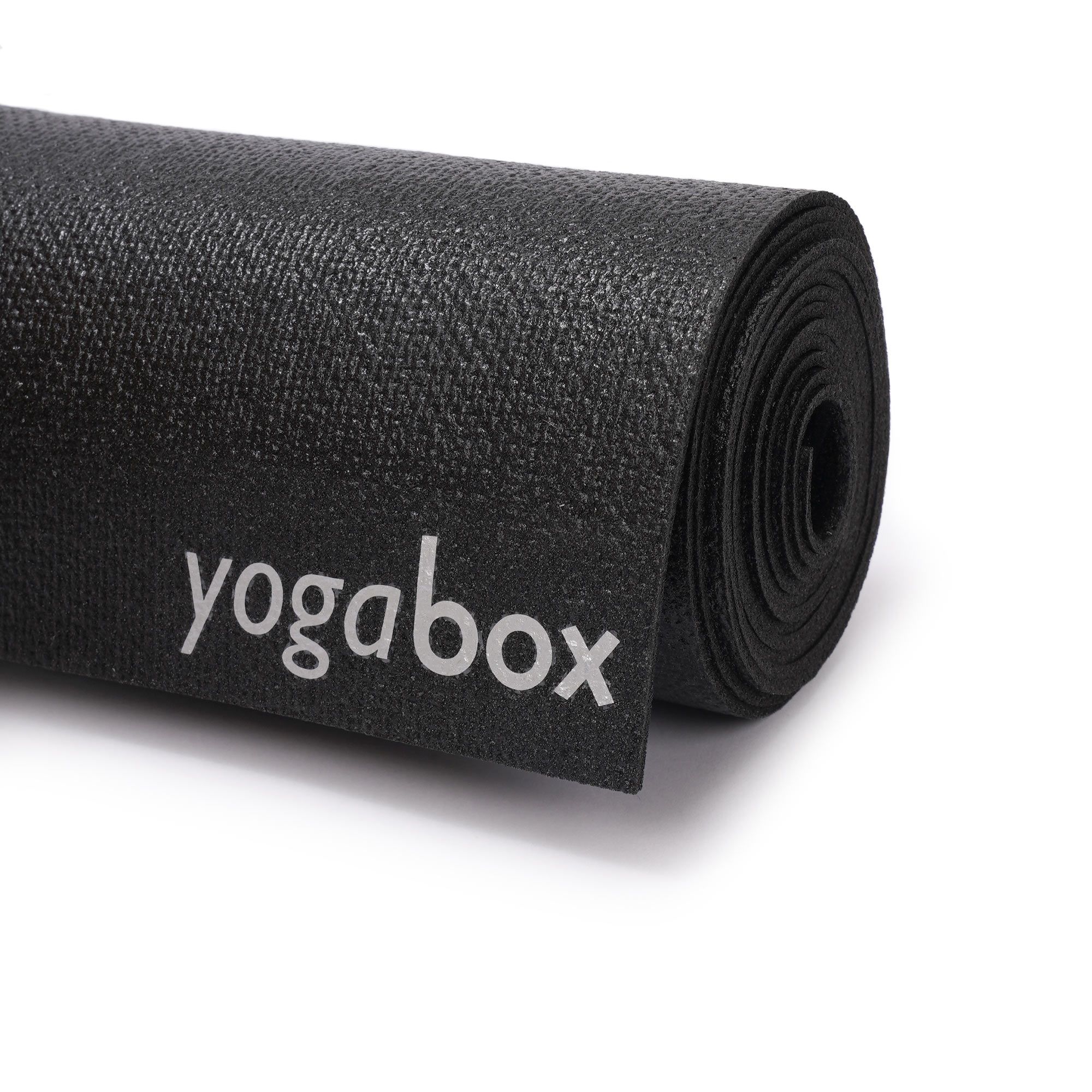 Nahaufnahme der schwarzen Yogamatte mit aufgerolltem Ende und 'yogabox'-Logo.