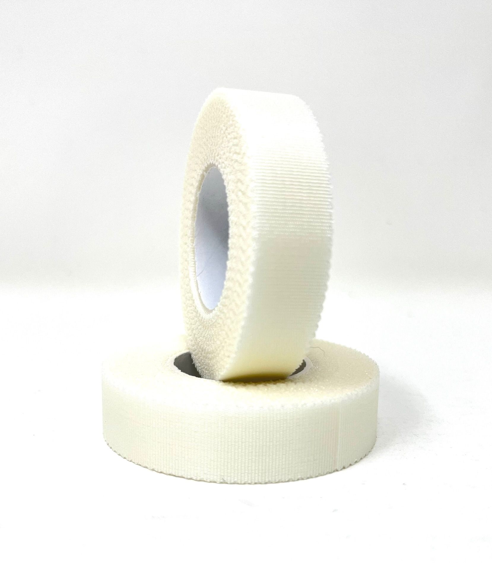 Zwei Rollen Silkafix Heftpflaster. Eine Rolle steht auf der anderen. Weißes, geriffeltes Material.