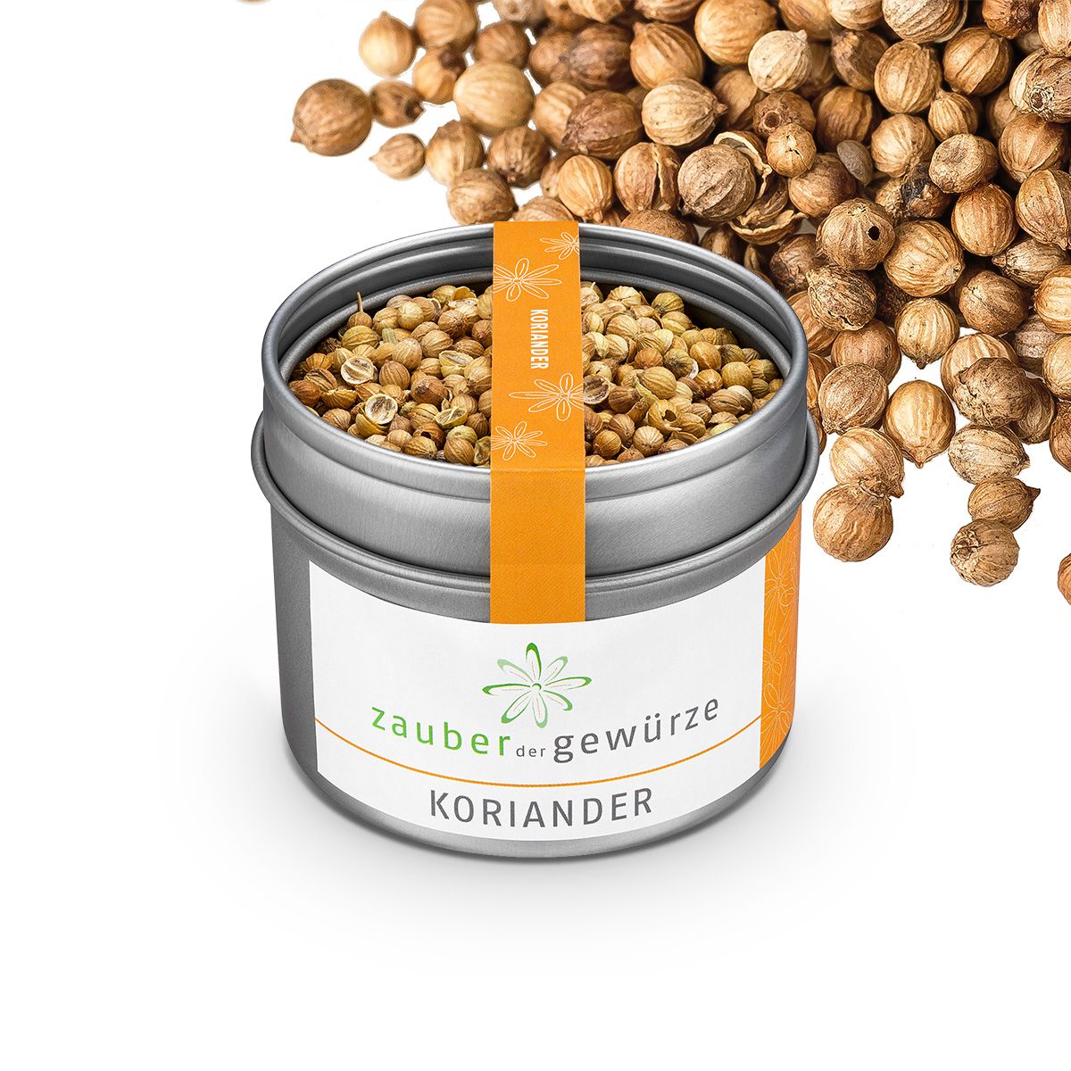 Koriandersamen in Dose und daneben. Dose mit Etikett: Zauber der Gewürze Koriander. Orangefarbener Streifen mit Koriander-Aufschrift. Samen liegen daneben.