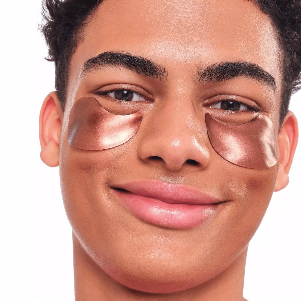 Ein Mann mit kupferfarbenen Augenpads unter beiden Augen.