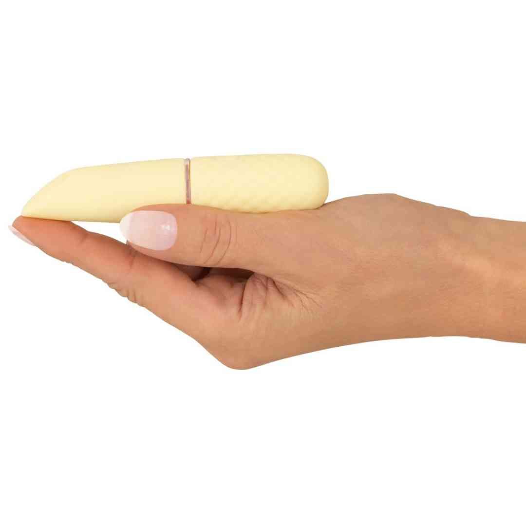 Gelber Vibrator in einer Hand gehalten. Sichtbar sind die Spitze und ein Teil des Griffs.