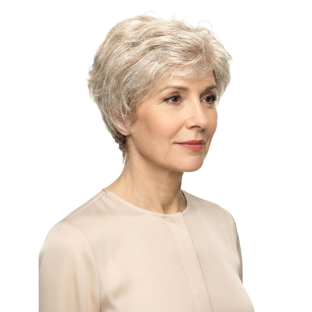 Kurzhaarperücke in Grau. Dreiviertelansicht einer Frau mit beigem Oberteil. Der Hintergrund ist weiß.