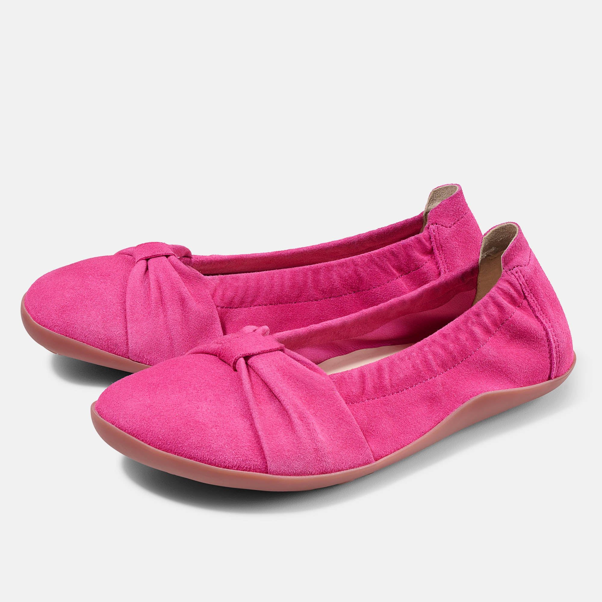 Zwei pinkfarbene Ballerinas. Obermaterial aus Wildleder, mit Schleife verziert. Flache Sohle.
