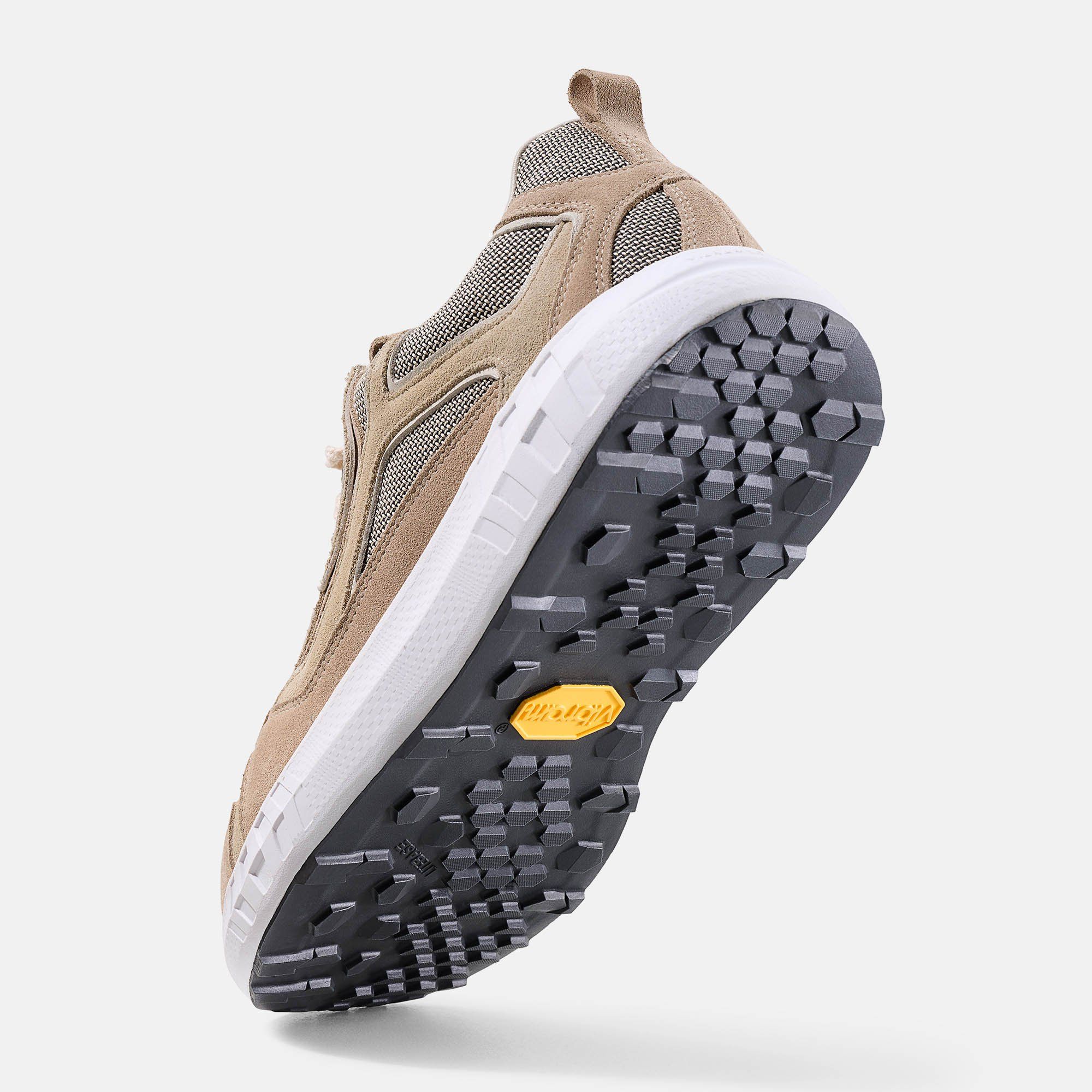 Schuh von unten. Schwarze Sohle mit Profil und gelbem Vibram-Logo. Weiße Zwischensohle. Beige Obermaterial.