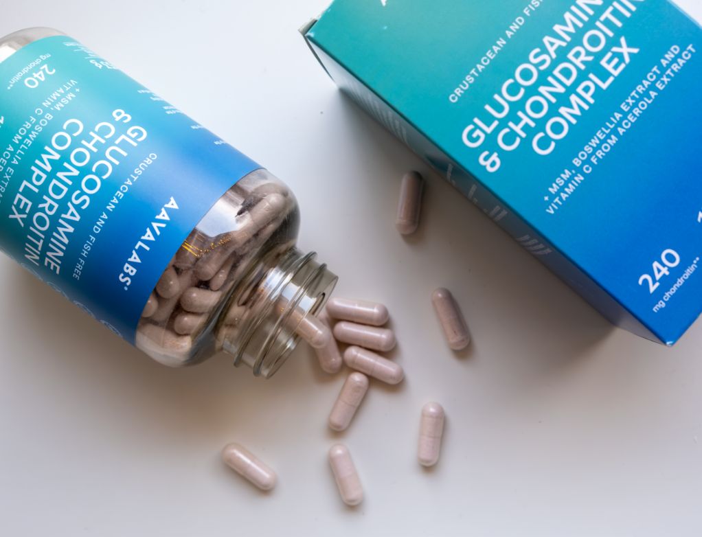 Glucosamin-Kapseln aus einer Flasche auf einer Oberfläche.