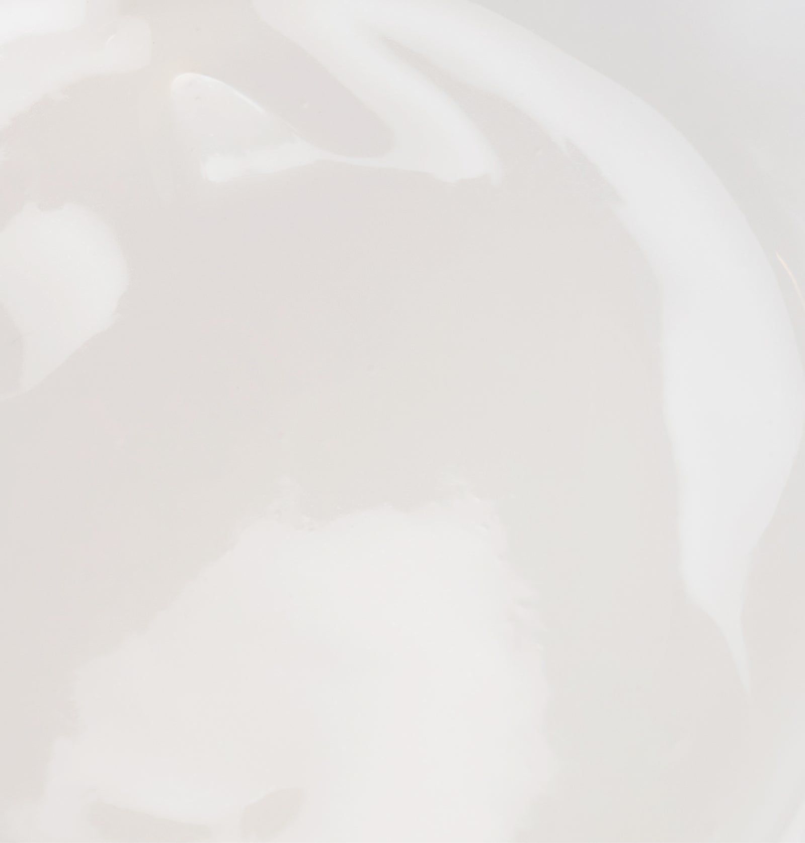 Nahaufnahme von weißer, glänzender Creme. Textur ist sichtbar.