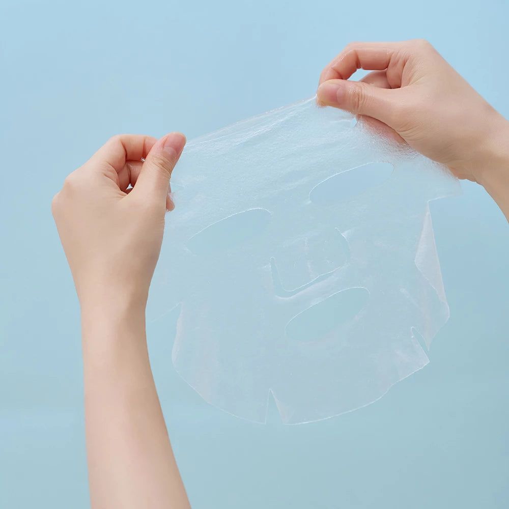 Transparente Gesichtsmaske aus Stoff, die von zwei Händen gehalten wird.