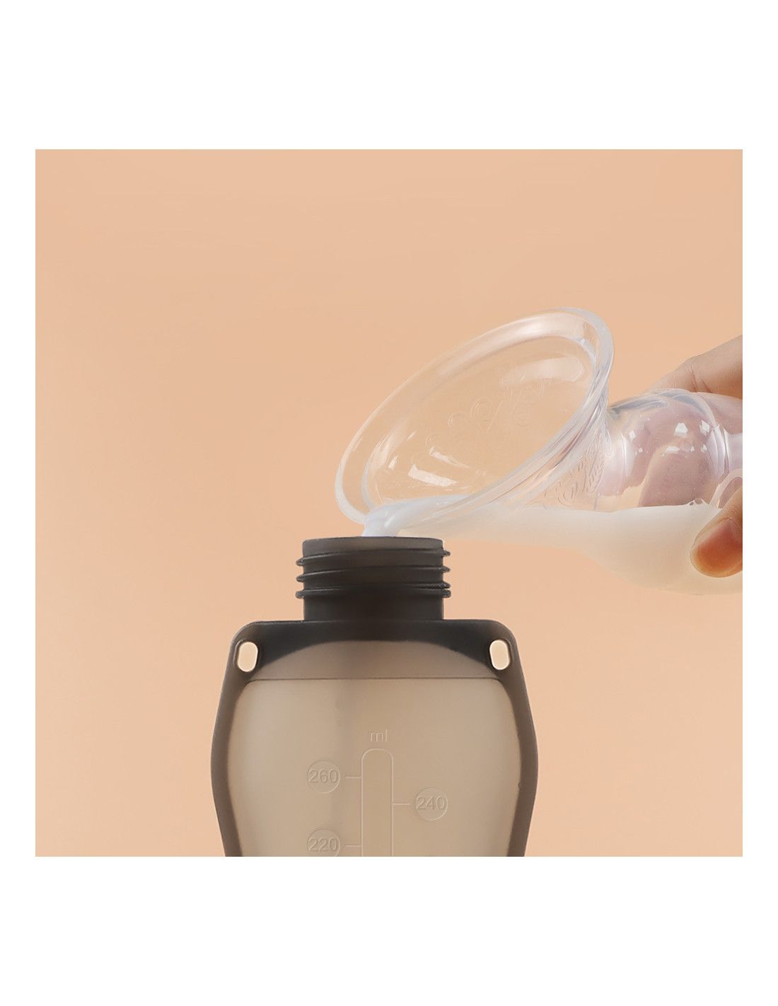 Eine transparente Pumpe gießt Flüssigkeit in eine graue Flasche. Helle Haut hält die Pumpe.