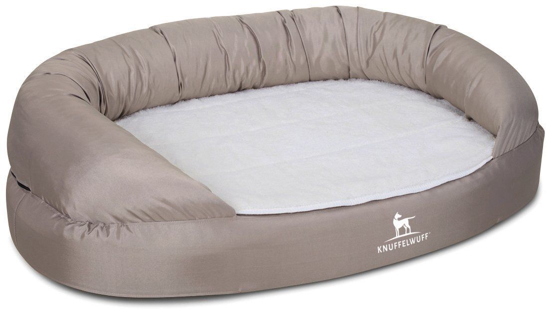 Orthopädisches Hundebett Jessy, beige. Oval. Gepolsterte Seiten. Knuffelwuff Logo. Weiße Liegefläche.