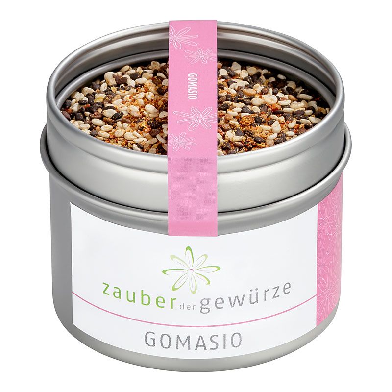 Metallbehälter mit Gomasio-Gewürzmischung. Rosa Etikett mit Schriftzug "Zauber der Gewürze" und "Gomasio".