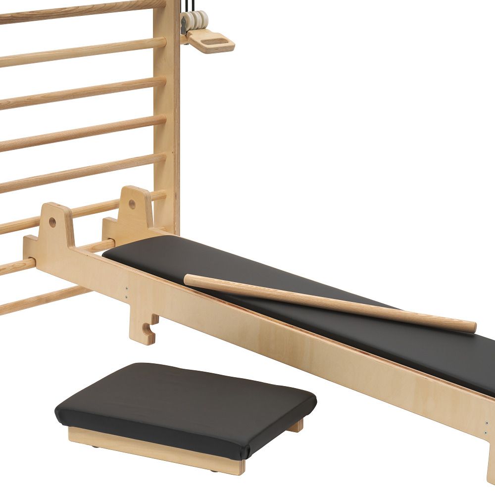 Sprossenwand mit Sprossen, schräger Bank, Holzstab und kleinem Polster.