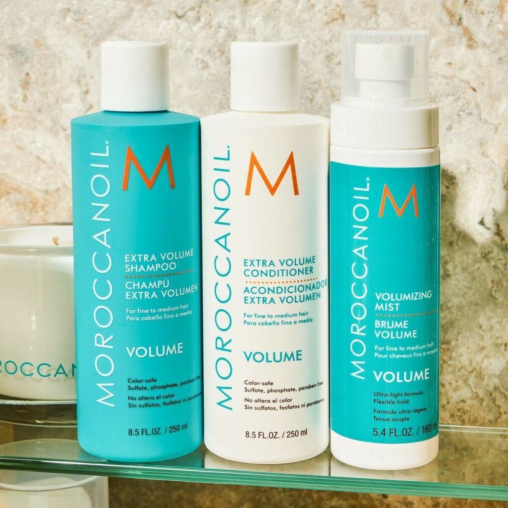 Drei Flaschen auf Glasablage. Text: Moroccanoil, Extra Volume Shampoo, Conditioner, Volumizing Mist. 250 ml, 160 ml.