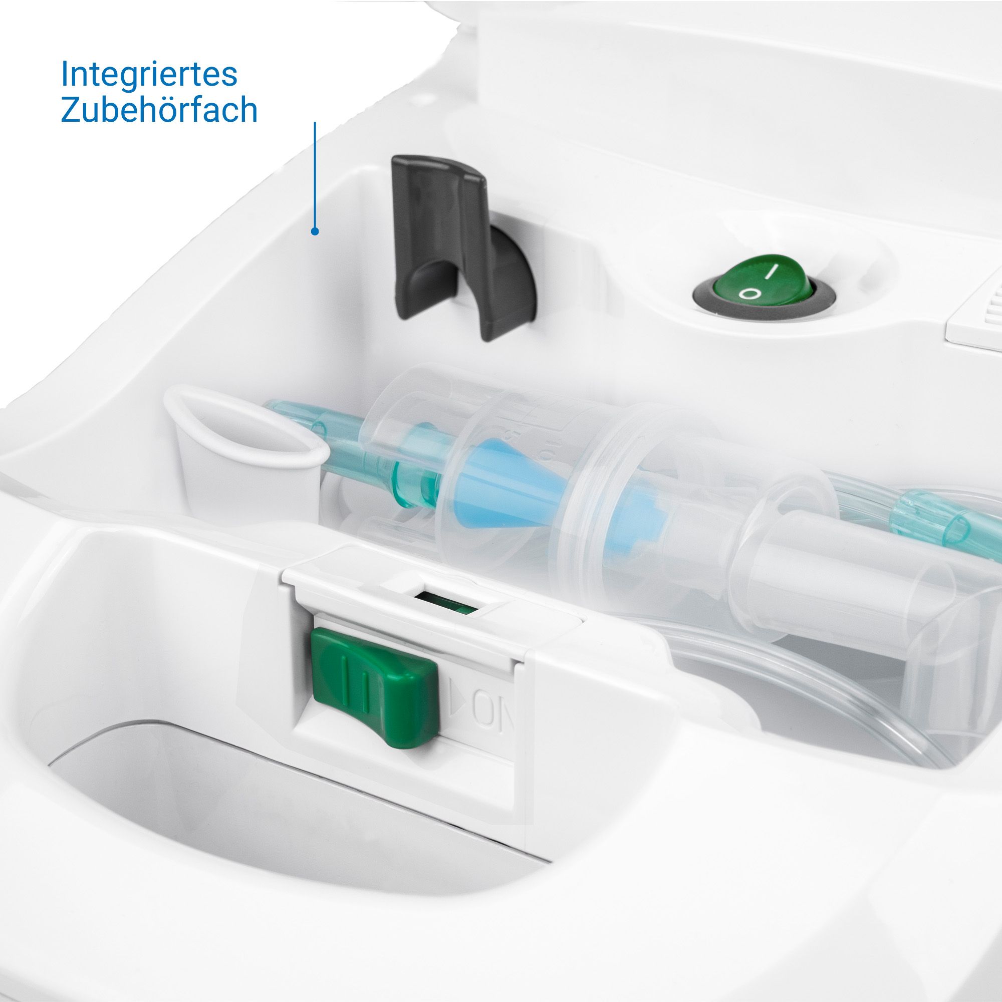 Detailansicht des Medisana Inhalators: Integriertes Zubehörfach mit Masken, Schläuchen und Aufsätzen. Grüner Ein-/Ausschalter.