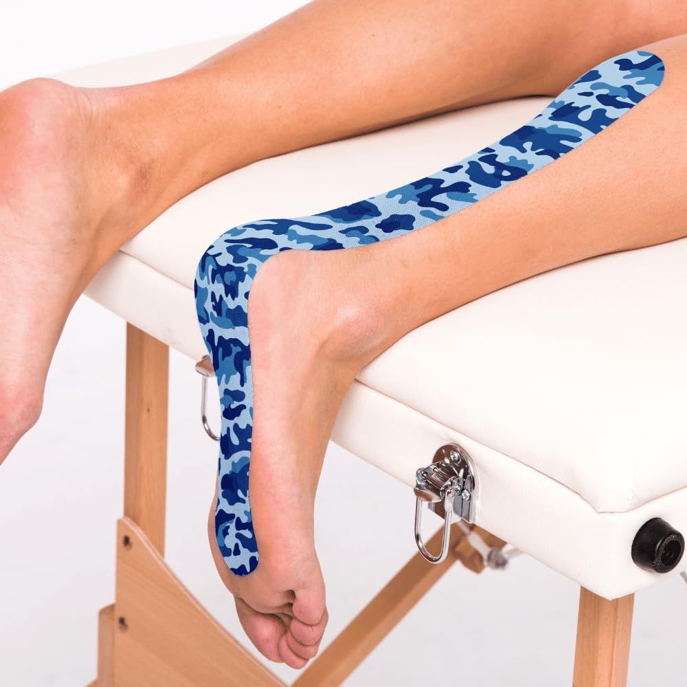 Bein mit CureTape am Fuß. Blaues Camouflage-Muster. Liege im Hintergrund.