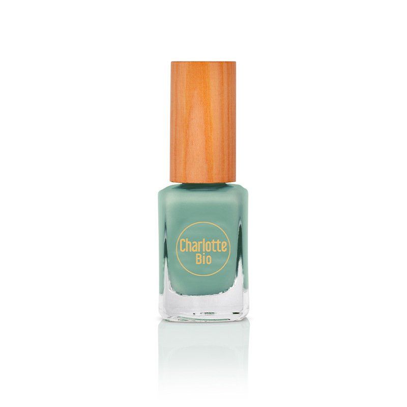 Nagellackflasche mit Holzdeckel. Auf dem Flakon steht "Charlotte Bio". Die Flüssigkeit ist wassergrün.