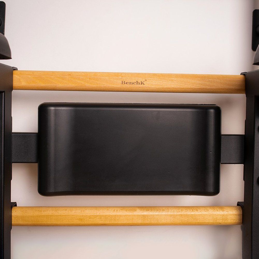 Detailansicht der Dip-Station. Schwarzes Polster, Holzsprossen und BenchK-Logo. Für Fitness.