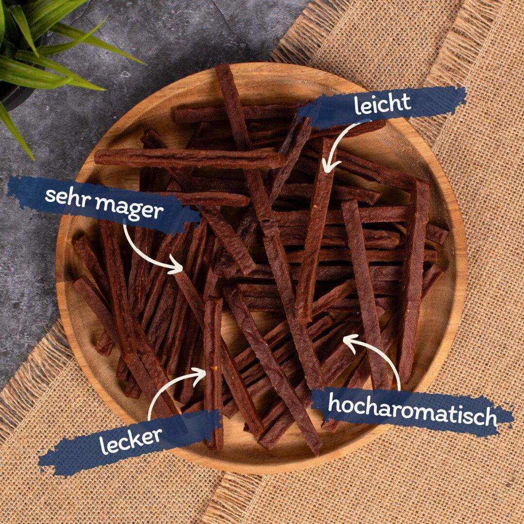 Holzschale mit Rinderdörrfleisch. Text-Labels: sehr mager, leicht, lecker, hocharomatisch.