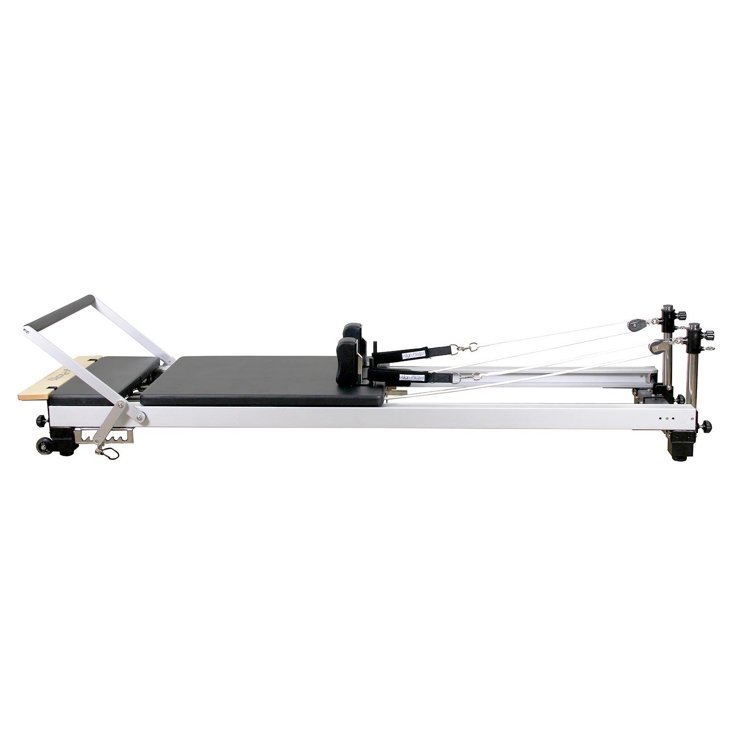 Pilates-Reformer mit niedrigen Beinen. Graue Polsterung, Metallrahmen, Räder an den Füßen.